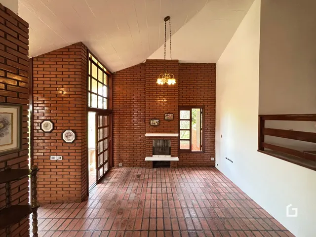 Sala com paredes de tijolo vermelho e piso de cerâmica.