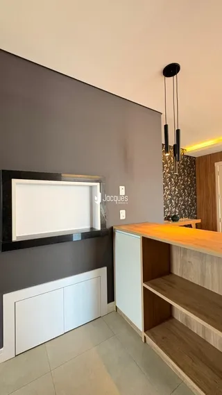 Interior de uma sala com parede cinza escura e detalhes em madeira.