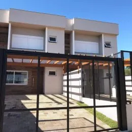 Fachada de uma residência em Lajeado, Brasil, com grandes janelas e portas de vidro.
