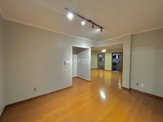 Hall de entrada com piso de madeira clara e paredes brancas.