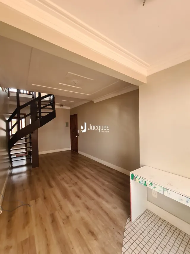 Hall com piso de madeira e escadaria em uma propriedade.