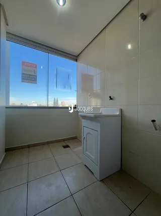 A foto mostra o interior de um banheiro com piso e paredes revestidos de cerâmica.