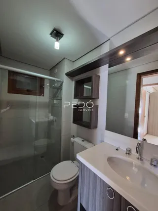 Foto de um banheiro moderno com box de vidro e louças sanitárias.