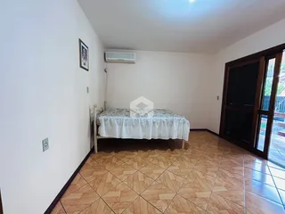 A foto mostra um quarto com cama e piso de cerâmica.