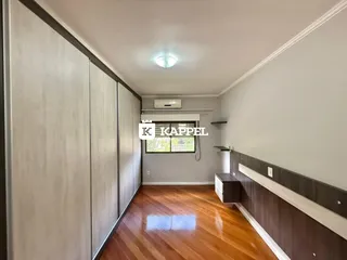 Foto de um corredor interno com armários embutidos e piso de madeira.