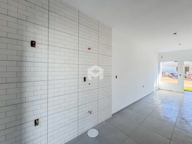 Parede com revestimento de azulejos brancos e piso de cerâmica cinza em um ambiente interno.