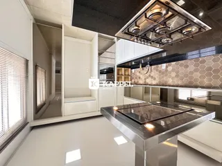 Cozinha moderna com ilha central de aço inoxidável e acabamentos contemporâneos.