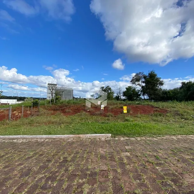 Vista externa de um terreno com grama e céu azul.