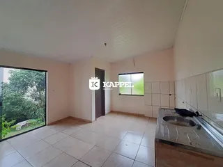 Interior de uma cozinha com piso de cerâmica e vista para o jardim.