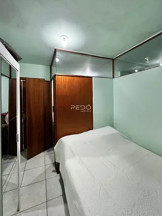 Quarto com cama e armários de madeira em um imóvel.