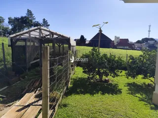 Vista externa de um terreno com cerca e vegetação.