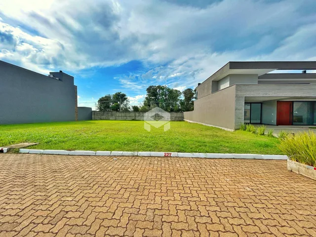 Vista externa de uma propriedade com jardim e área pavimentada.