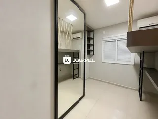 Interior de um cômodo com paredes brancas e persianas brancas na janela.
