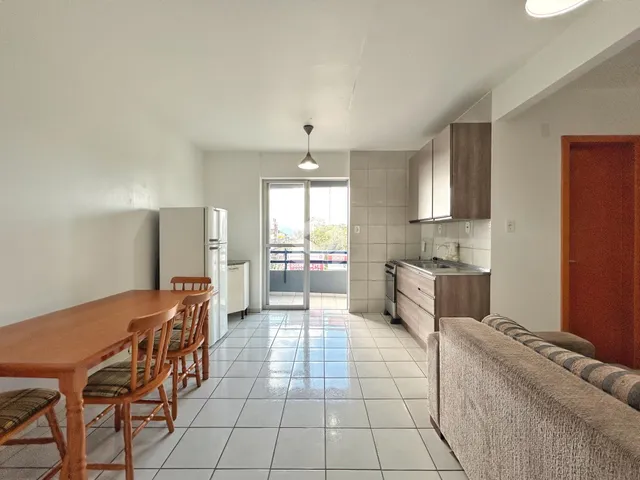 Sala de jantar e cozinha com piso de cerâmica em um imóvel em Lajeado.