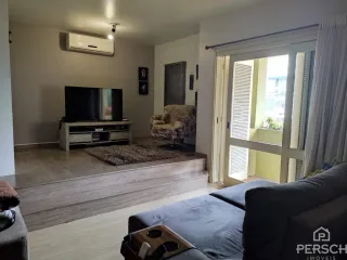 Sala de estar com sofá e televisão em ambiente interno.