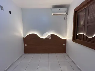 Corredor com painel de madeira e piso de cerâmica branca.