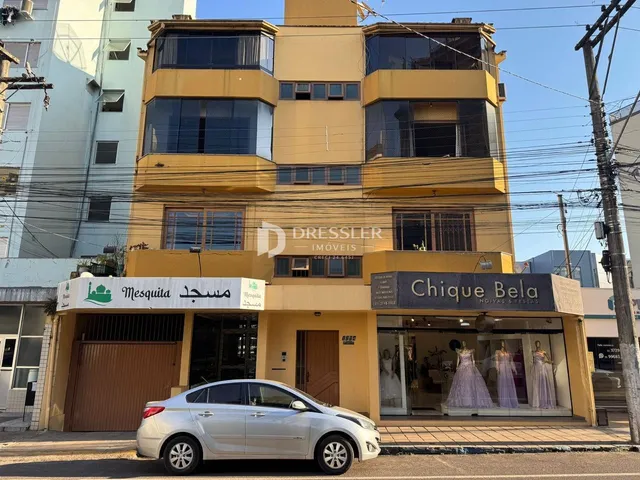 Fachada de um prédio residencial em Lajeado, Brasil, com lojas comerciais no térreo.