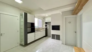 Interior de uma sala com piso de cerâmica e armários brancos.