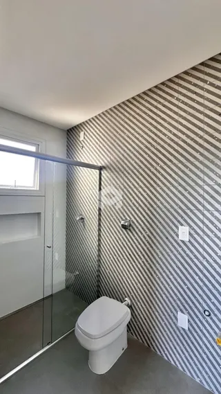 Banheiro com revestimento de parede listrado cinza e branco.