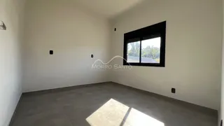 Foto de um cômodo vazio com paredes brancas e piso cinza.
