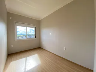 Sala de estar com piso de madeira e vista da paisagem através da janela.