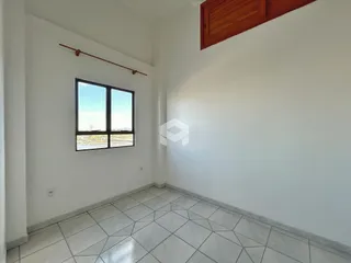 Ambiente interno com piso de cerâmica e grande janela.