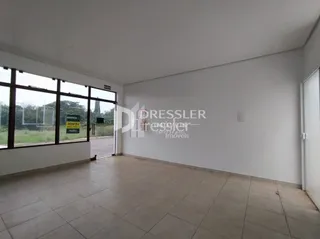 Ambiente interno de uma sala com piso de cerâmica e grandes janelas.