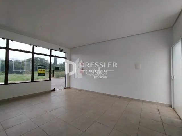 Ambiente interno de uma sala com piso de cerâmica e grandes janelas.