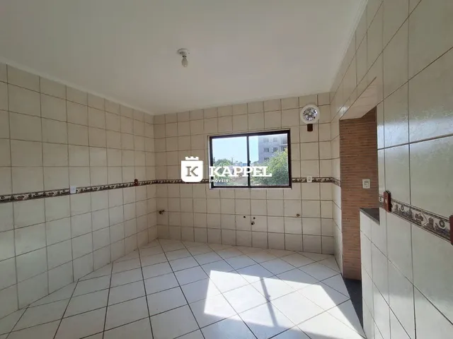 Foto de um corredor interno com paredes de azulejo e piso de cerâmica.