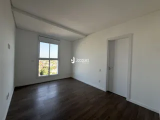 Sala de estar com piso de madeira clara e janela.
