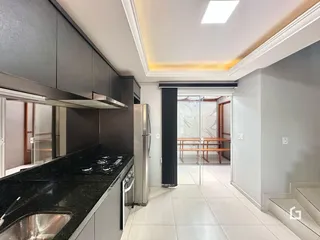 Vista da cozinha moderna com armários escuros e piso claro.