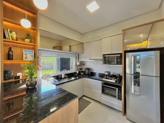Vista da cozinha moderna com armários e bancadas escuras.