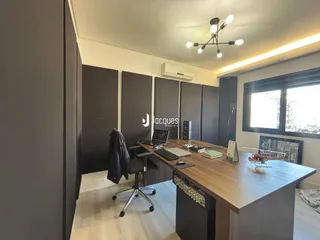 Foto de um escritório moderno com mesa de madeira e paredes cinzas.