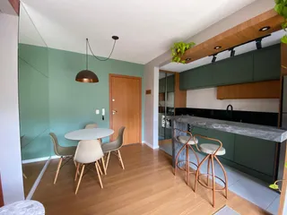 Sala de jantar com mesa e cadeiras em um ambiente com piso de madeira.