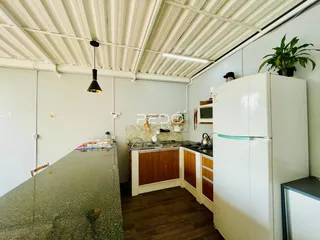 Foto de uma cozinha com armários brancos e piso de madeira.