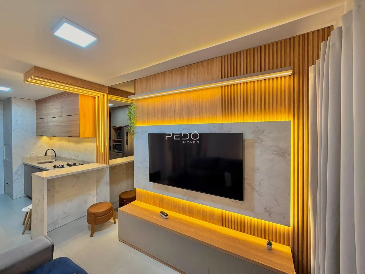 Sala de estar moderna com painéis de madeira e iluminação em destaque.