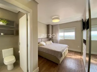 Quarto com cama e porta de banheiro em um imóvel.