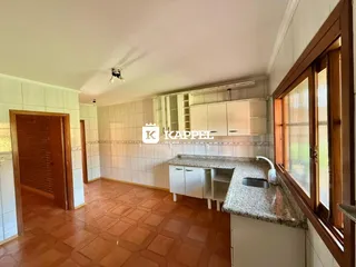 Esta é uma foto da cozinha com armários brancos e piso de terracota.