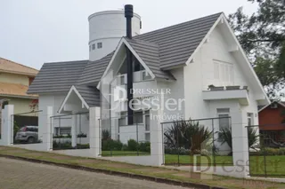 Fachada de uma casa branca com telhado escuro em Lajeado.