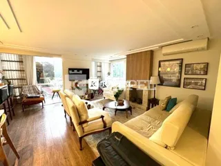 Foto interna de uma sala de estar com piso de madeira.
