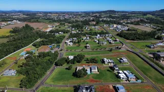Vista aérea de uma área residencial com estradas e terrenos verdes em Lajeado, Brasil.