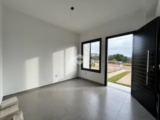 Sala de estar com paredes brancas e piso de cerâmica cinza.