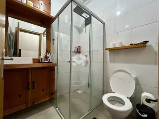 Foto de um banheiro com box de vidro e vaso sanitário em Lajeado.
