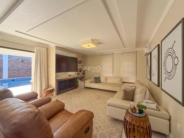 Sala de estar com sofás e televisão em um apartamento no Brasil.