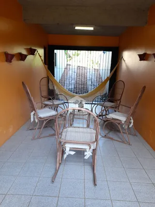 Uma sala com cadeiras de madeira e paredes laranjas.