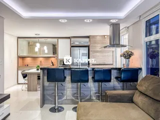 Cozinha moderna com ilha e bancos de bar em um ambiente bem iluminado.