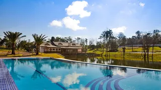 Vista da piscina e paisagem verde ao redor.
