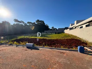 Vista externa do terreno com cerca e vegetação ao redor da propriedade.