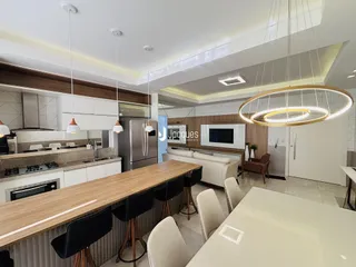 Interior de uma sala de estar e cozinha moderna em um imóvel no Brasil.