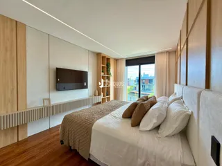 Quarto com cama e painéis de madeira na residência.